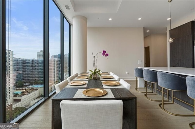 dining room with floor to ceiling windows and light wood-type flooring