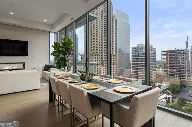 dining space with expansive windows and hardwood / wood-style floors