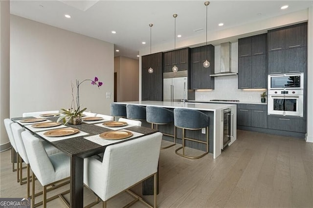 dining room with beverage cooler and light hardwood / wood-style floors