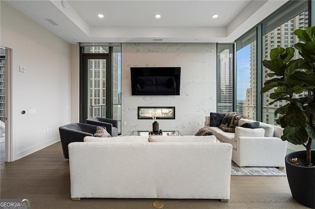 living room with wood-type flooring and a high end fireplace