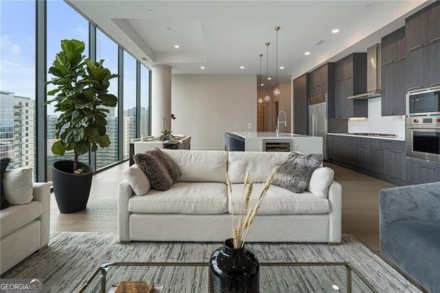 living room featuring expansive windows and light hardwood / wood-style flooring