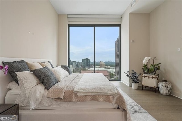 bedroom with hardwood / wood-style floors and access to outside