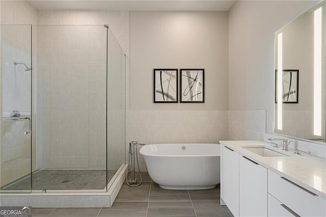 bathroom with vanity, separate shower and tub, tile walls, and tile patterned floors