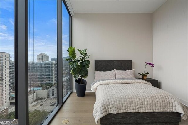 bedroom featuring floor to ceiling windows and light hardwood / wood-style flooring