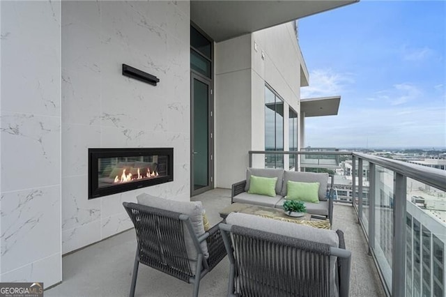 balcony featuring an outdoor living space with a fireplace