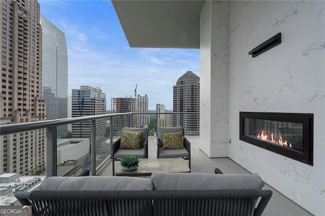 balcony with an outdoor living space with a fireplace