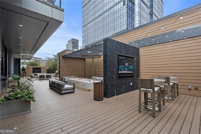 deck featuring an outdoor living space with a fire pit