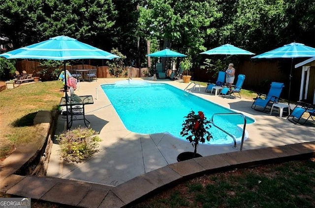 view of swimming pool featuring a patio area and a lawn