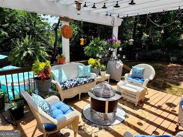 wooden terrace featuring a pool, an outdoor fire pit, and a pergola