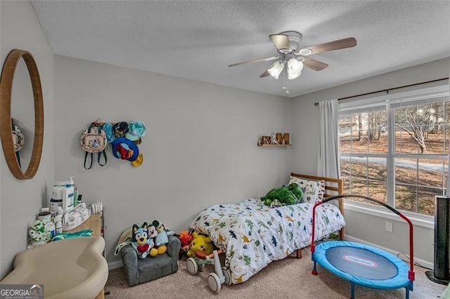 bedroom featuring ceiling fan, carpet floors, and a textured ceiling