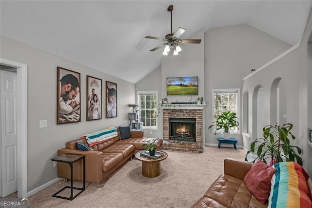 living room with ceiling fan, carpet floors, a brick fireplace, and a wealth of natural light