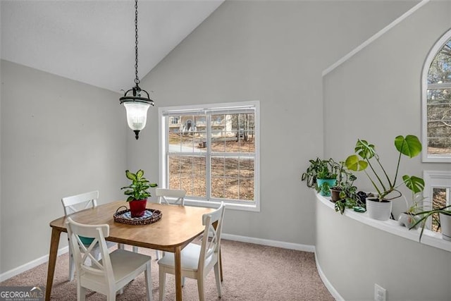 dining area featuring lofted ceiling and carpet flooring