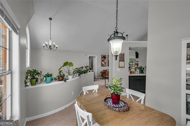 carpeted dining area featuring lofted ceiling and a notable chandelier