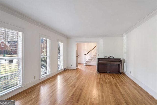 unfurnished room featuring ornamental molding and light hardwood / wood-style floors