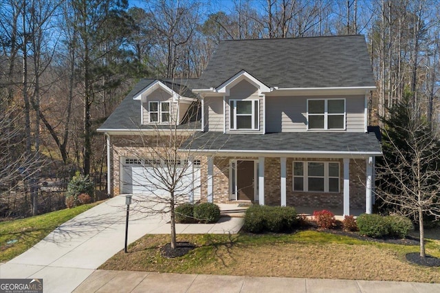 view of front facade with a porch, a front yard, brick siding, and driveway