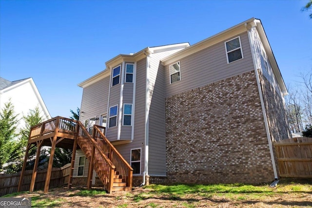 back of house with fence, stairway, and a wooden deck