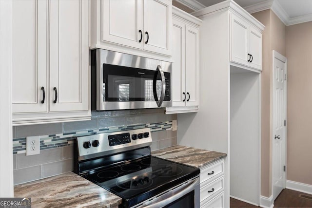 kitchen with white cabinets, decorative backsplash, appliances with stainless steel finishes, ornamental molding, and light stone countertops