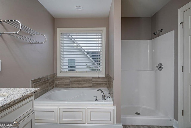 full bath featuring a stall shower, vanity, and a bath