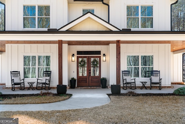 view of exterior entry featuring french doors and a porch