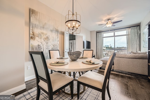 dining space featuring dark wood-type flooring and ceiling fan with notable chandelier