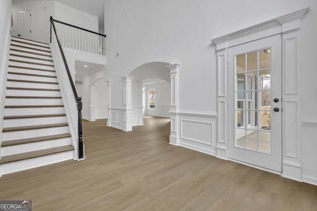 foyer entrance with light hardwood / wood-style flooring and ornate columns