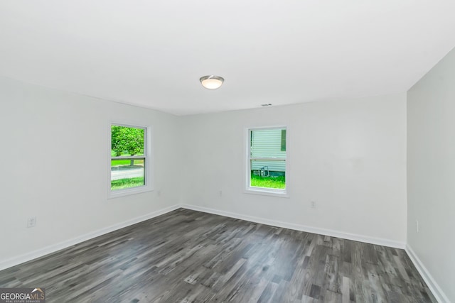 unfurnished room with dark hardwood / wood-style flooring