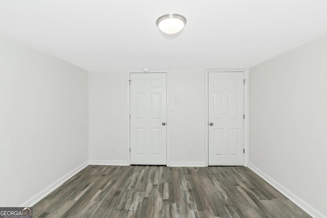 unfurnished bedroom with dark hardwood / wood-style flooring