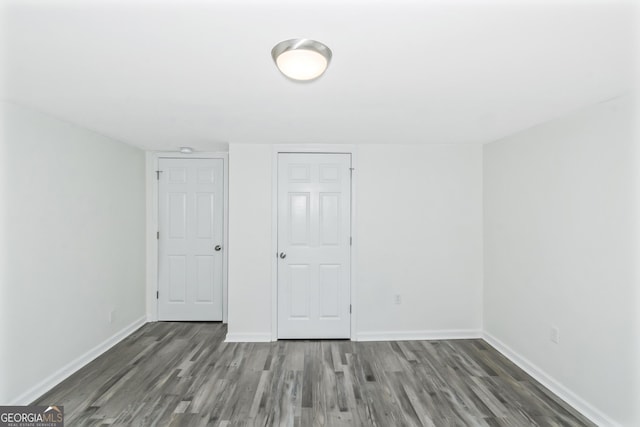 unfurnished bedroom featuring dark wood-type flooring and a closet