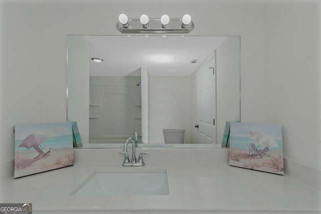 bathroom featuring walk in shower, vanity, and toilet