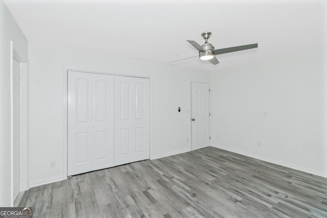 unfurnished bedroom with ceiling fan, light hardwood / wood-style floors, and a closet