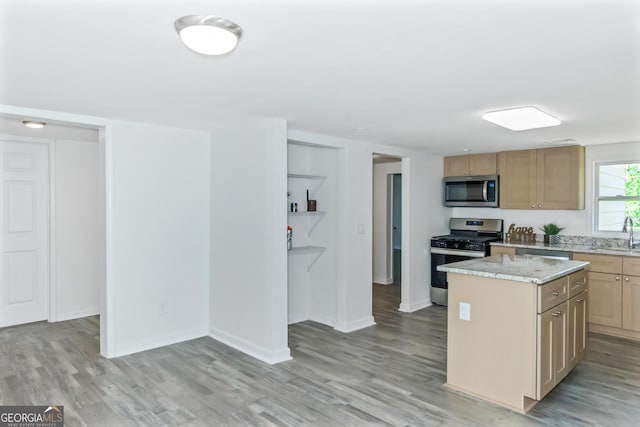 kitchen featuring sink, stainless steel appliances, light hardwood / wood-style floors, a kitchen island, and light brown cabinets