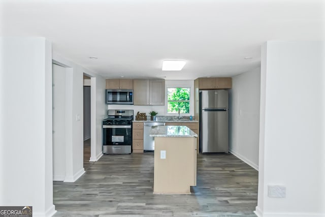 kitchen featuring a center island, stainless steel appliances, light brown cabinetry, and wood-type flooring