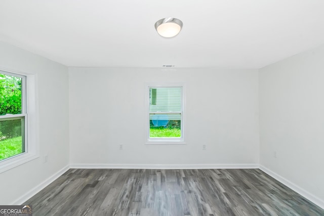 unfurnished room with a wealth of natural light and dark hardwood / wood-style flooring