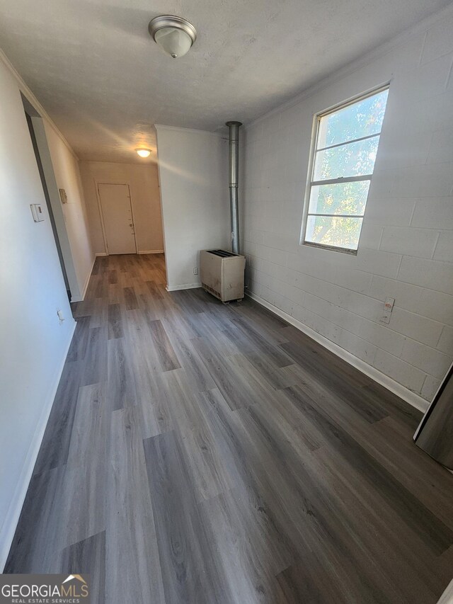 spare room with hardwood / wood-style floors, a textured ceiling, and a wood stove