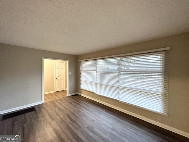 spare room with wood-type flooring and a textured ceiling