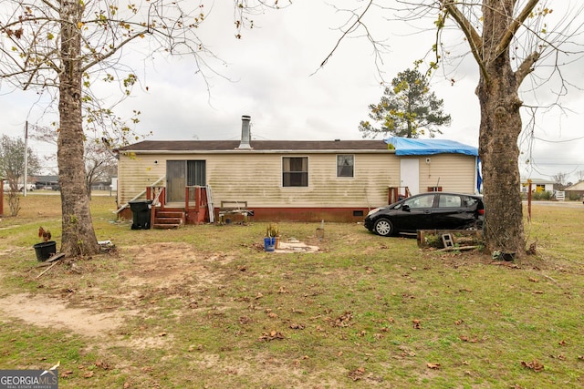 rear view of property featuring a lawn