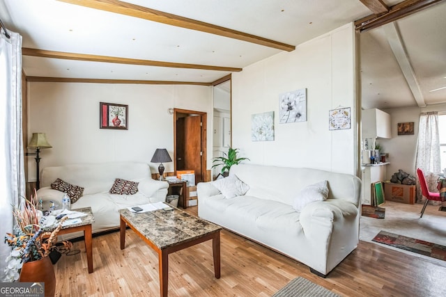 living room featuring vaulted ceiling with beams and light hardwood / wood-style flooring