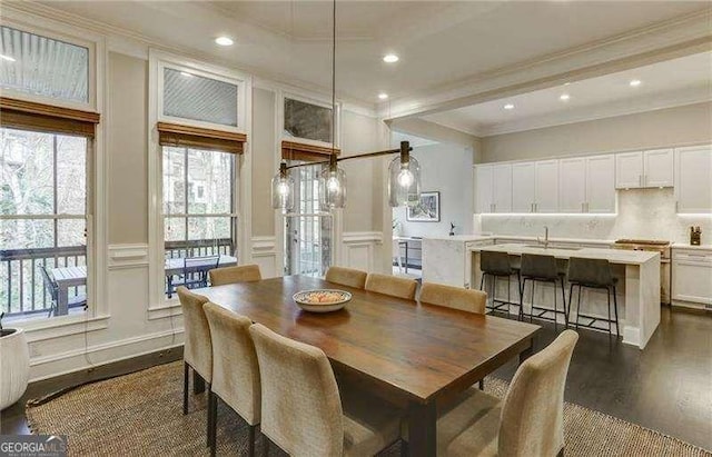 dining space with beamed ceiling, ornamental molding, dark hardwood / wood-style floors, and sink