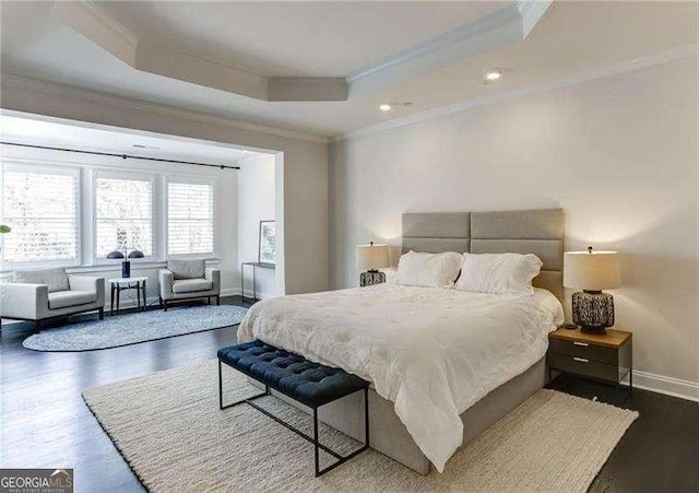 bedroom with dark wood-type flooring, ornamental molding, and a tray ceiling