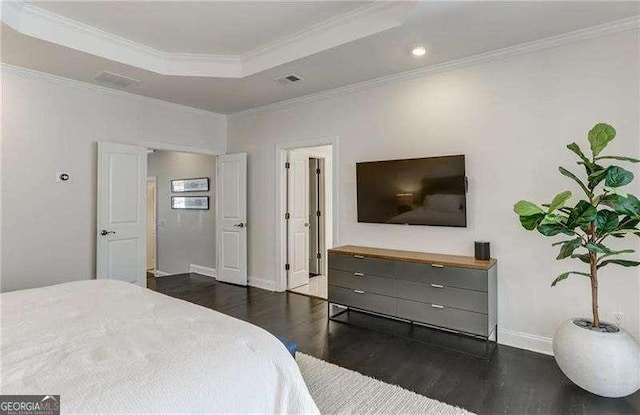 bedroom featuring ornamental molding, dark hardwood / wood-style floors, and a raised ceiling