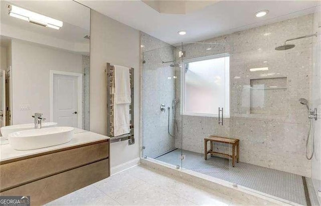 bathroom with a shower with door, vanity, and tile patterned floors