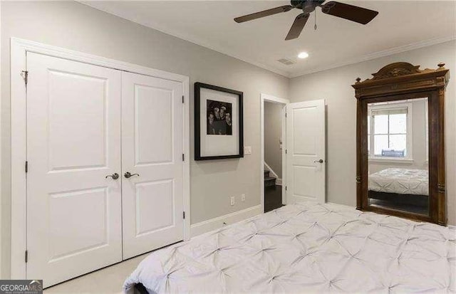 bedroom featuring ornamental molding, ceiling fan, and a closet