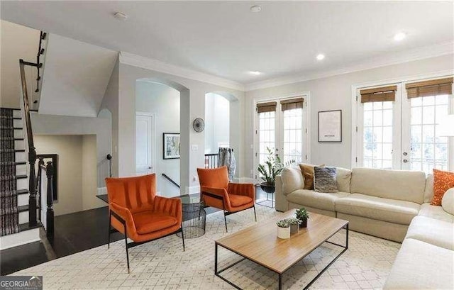 living room with french doors, ornamental molding, and light hardwood / wood-style floors