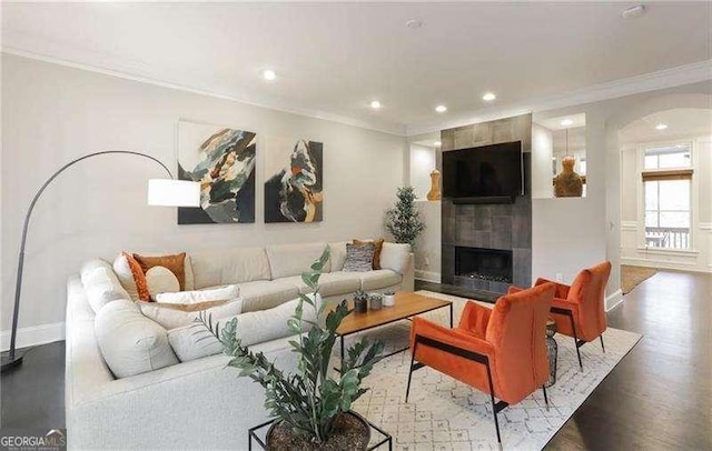 living room with crown molding, dark hardwood / wood-style floors, and a fireplace