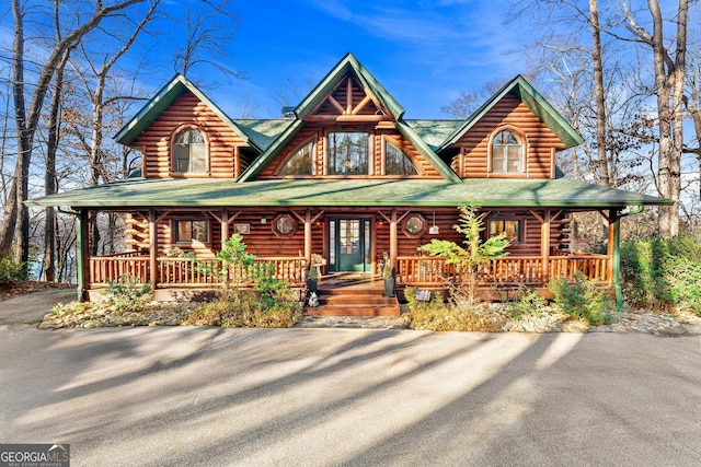 log home featuring covered porch