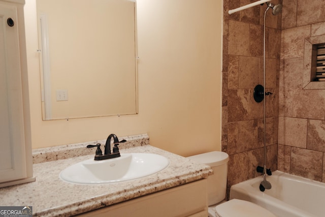 full bathroom featuring tiled shower / bath combo, vanity, and toilet