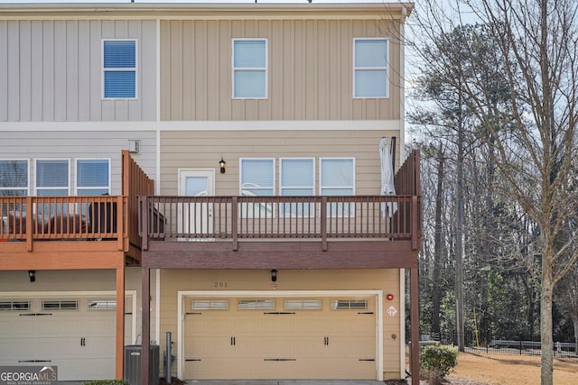 back of house with a garage and central air condition unit