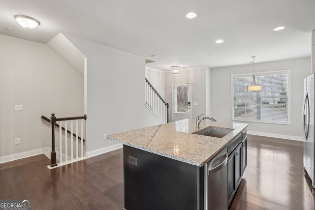 kitchen with dark wood-type flooring, sink, hanging light fixtures, an island with sink, and stainless steel appliances