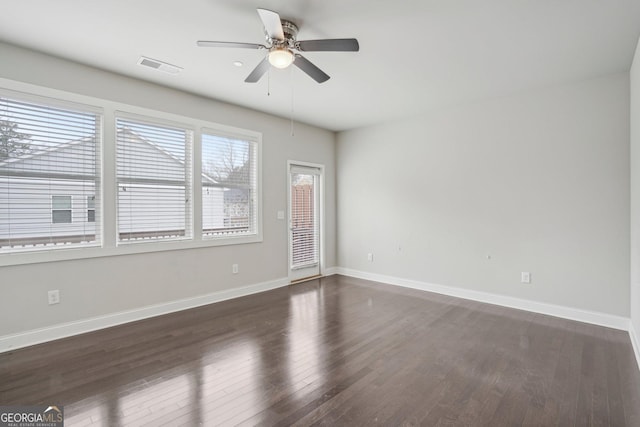 empty room featuring dark wood-type flooring and ceiling fan