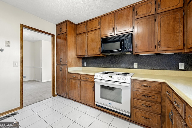 kitchen with white electric range, a textured ceiling, and light tile patterned floors